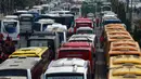 Banyaknya bus-bus yang mengangkut ratusan buruh parkir di badan jalan mengakibatkan kemacetan di kawasan Sudirman, Jakarta, Kamis (1/5/14). (Liputan6.com/Johan Tallo)