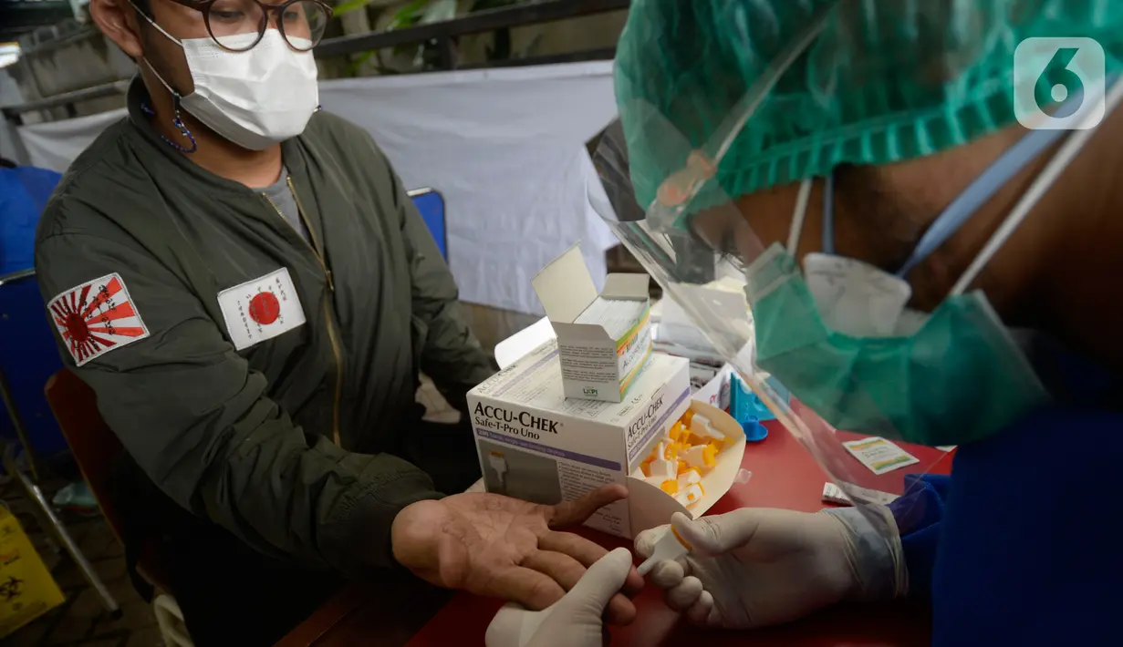 Petugas kesehatan mengambil sampel darah anggota KPPS saat rapid test Covid-19 di kantor Kelurahan Pondok Benda, Tangerang Selatan, Jumat (27/11/2020). Rapid test dilakukan guna mengantisipasi penyebaran Covid-19 saat pemungutan suara Pilkada Kota Tangerang Selatan 2020. (merdeka.com/Dwi Narwoko)