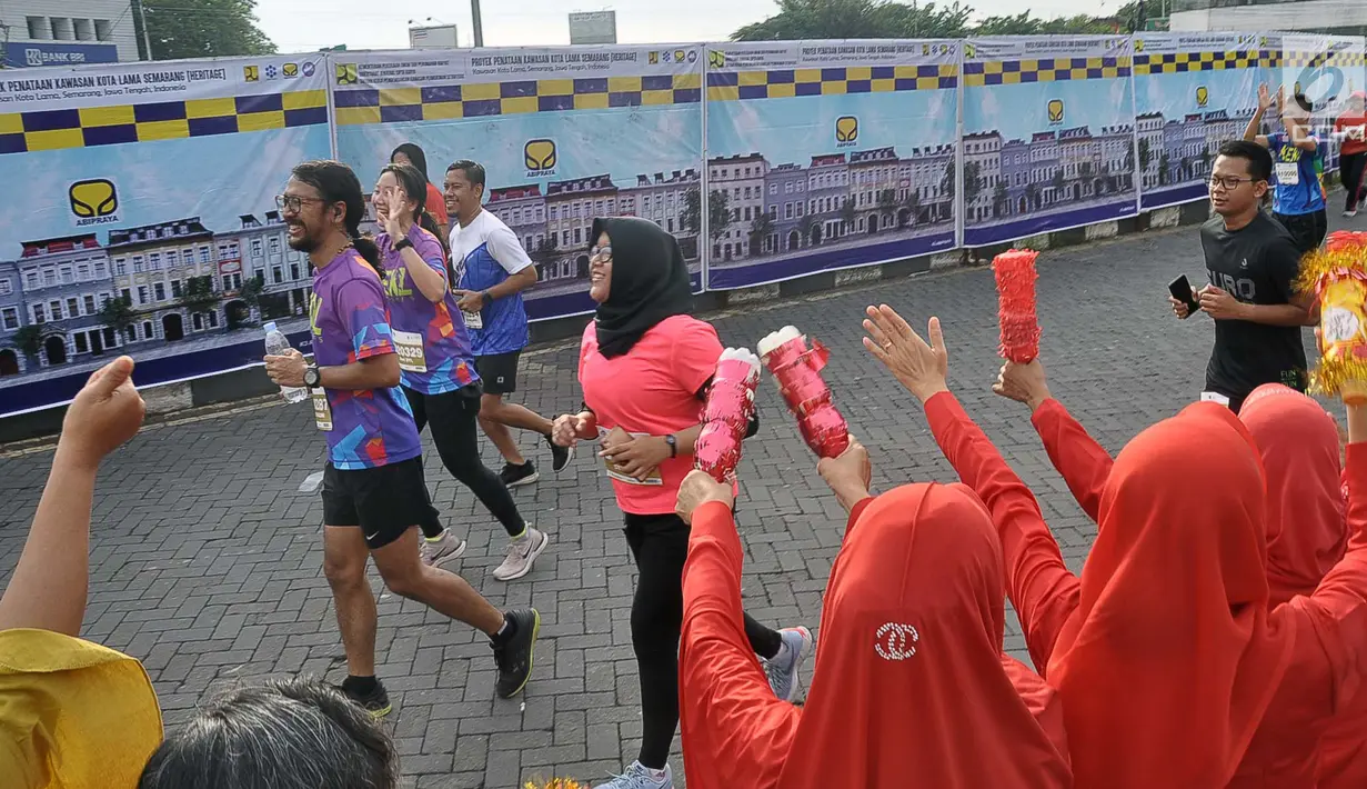 Penonton memberi semangat pada pelari yang mengikuti Semarang 10K di Kota Semarang, Jawa Tengah, Minggu (16/12). Meski baru pertama kali digelar, antusias peserta cukup tinggi. (Liputan6.com/Gholib)