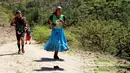 Wanita suku Raramuri dari ras Tarahumara mengenakan sandal saat mengikuti lomba lari maraton Ultra Trail Cerro Rojo di Chihuahua, Meksiko, Sabtu (15/7). Orang-orang dari suku asli Tarahumara dikenal sebagai pelari yang hebat. (Herika MARTINEZ/AFP)