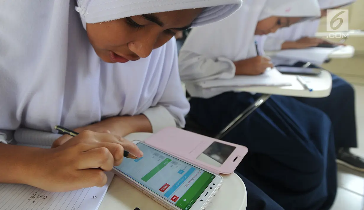Pelajar menggunakan ponsel android mengikuti babak penyisihan lomba matematika dengan metode Gasing (Gampang Asyik & Menyenangkan) di SMKN 1 Leuwiliang, Bogor, Selasa (8/1). Kegiatan itu diikuti pelajar tingkat SD hingga SMA.  (Merdeka.com/Arie Sunaryo)