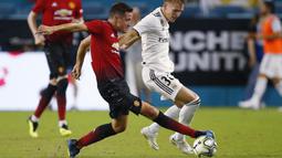 Gelandang Manchester United, Ander Herrera, berebut bola dengan striker Real Madrid, Martin Odegaard, pada laga ICC 2018 di Miami Gardens, Rabu (1/8/2018). Manchester United menang 2-1 atas Real Madrid. (AP/Brynn Anderson)