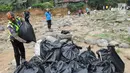 Anggota Polantas Polres Bogor merapihkan kantung berisi sampah di kawasan aliran Sungai Ciliwung, gadog, Bogor (20/9). Selain membersihkan sungai, dilakukan pembersihan  jalan jalur wisata puncak dari sampah dan ranjau paku. (Merdeka.com/Arie Basuki)