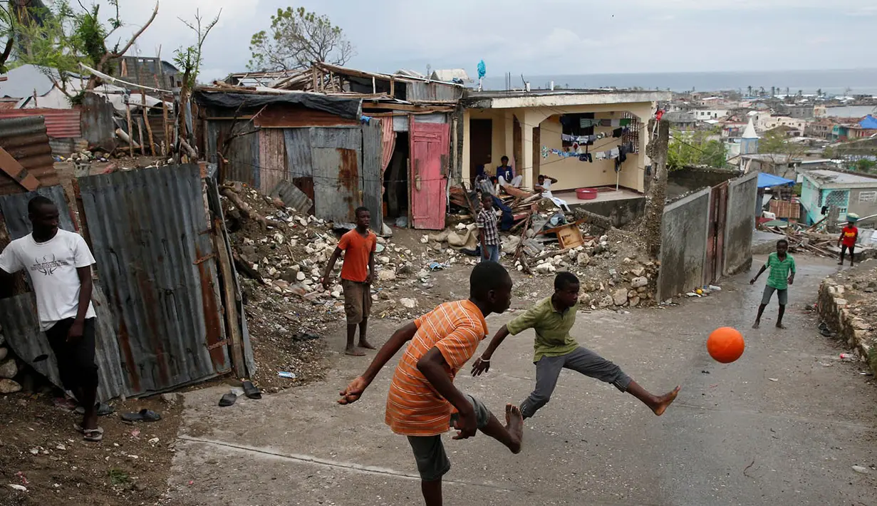 Foto Olahraga Terbaik - Anak-anak korban badai Matthew menghibur diri dengan bermain sepak bola di Jeremie, Haiti, Kamis (20/10/2016). (Reuters/Carlos Garcia Rawlins)