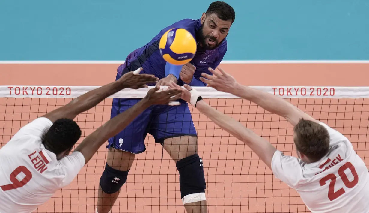 Atlet bola voli asal Prancis, Earvin Ngapeth (tengah) melakukan spike dan berusaha dihadang pemain Polandia Wilfredo Leon Venero dan Mateusz Bieniek, dalam pertandingan perempat final bola voli putra pada Olimpiade Tokyo 2020, Selasa (3/8/2021). (Foto: AP/Manu Fernandez)