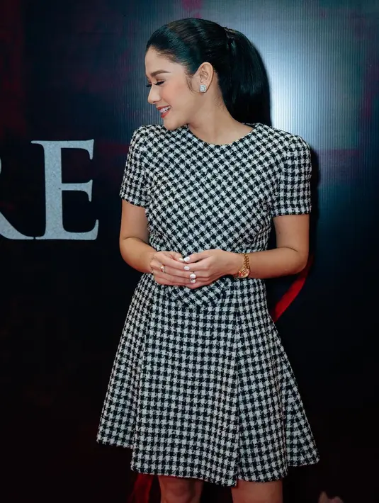 Naysilla Mirdad setidaknya dua kali ganti penampilan di gala premier film Inang. Pertama, ia tampil kasual dengan gaun pendek bermotif kotak-kotak rapat dalam nuansa monokrom. Gaun rilisan rumah mode Versace ini menampilkan kaki jenjang dan postur tubuh Naysilla Mirdad yang langsing. Rambutnya dikuncir, meng-highlight helai demi helai yang hitam rapi. (Foto: Dok. Instagram @naymirdad)
