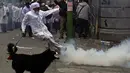 Mahasiswa kedokteran menendang gas air mata saat demonstrasi dekat lapangan Murilo di La Paz, Bolivia (19/12). Para dokter ini juga melakukan mogok makan dari senin kemarin. (AFP Photo/Jorge Bernal)