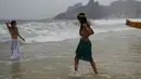 Dua wanita anggota gerakan topless mengumbar payudaranya saat melakukan ritual untuk Lemanja di Pantai Arpoador, Rio de Janeiro, Brasil, Senin (2/2/2015). (AFP Photo/Yasuyoshi Chiba)