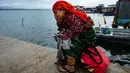 Seorang perempuan Penduduk Asli Guna menunggu di dermaga untuk pemindahannya dari pulau Carti Sugtupu ke daratan, di Guna Yala Comarca, di pantai Karibia di Panama, pada 03 Juni 2024. (MARTIN BERNETTI / AFP)
