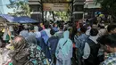 Peziarah berdesakan di pintu masuk TPU Karet Bivak, Jakarta, Rabu (6/7). Padatnya peziarah menyebabkan arus lalu lintas di depan TPU menjadi tersendat karena warga memarkir kendaraan di badan jalan. (Liputan6.com/Yoppy Renato)