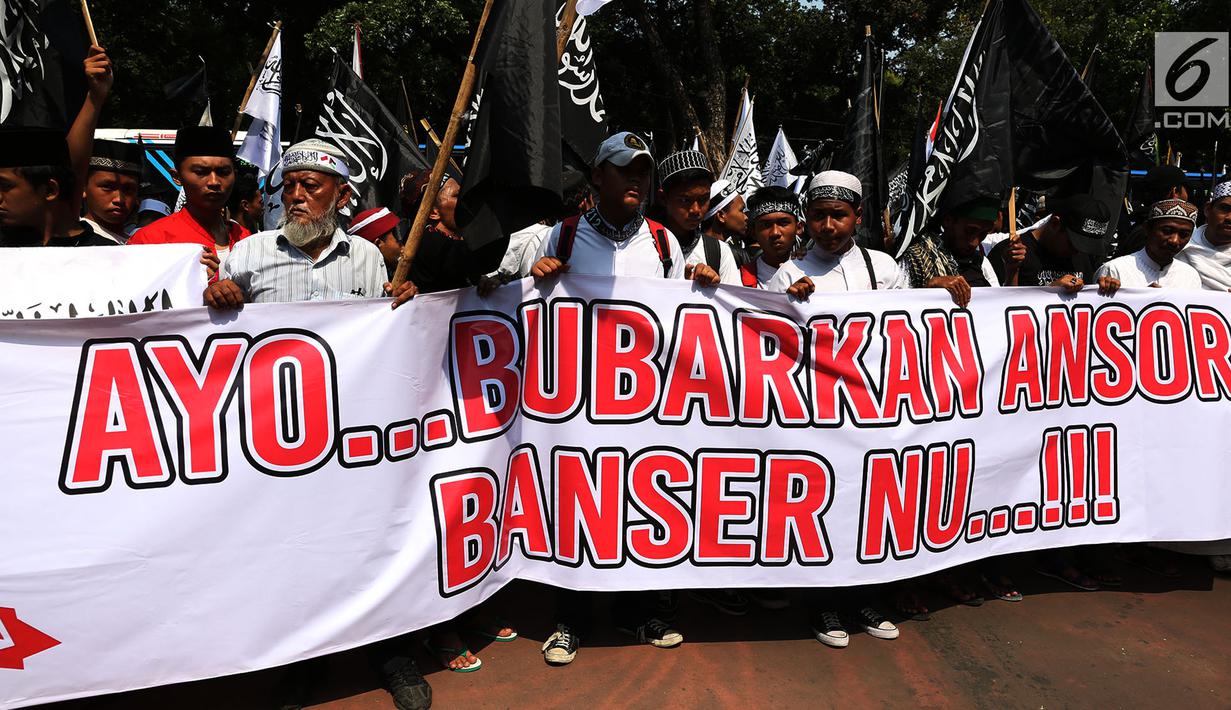 Massa Aksi Bela Tauhid membentangkan spanduk berisi tuntutan di depan Gedung Kemenko Polhukam, Jakarta, Jumat (26/10). Aksi ini mengkibatkan sejumlah ruas jalan mengalami kemacetan. (Merdeka.com/Imam Buhori)