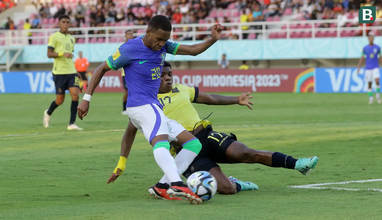 <p>Pemain Timnas Ekuador U-17, Yorkaeff Caicedo (kanan) berusaha menghalau bola tendangan pemain Brasil U-17, Estevao dalam pertandingan babak 16 Besar Piala Dunia U-17 di Stadion Manahan, Solo, Senin (20/11/2023). (Bola.com/Arief Bagus)</p>