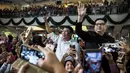 Peniru Presiden Filipina Rodrigo Duterte, Cresencio Extreme (tengah) dan peniru pemimpin Korea Utara Kim Jong Un, Howard X melambaikan tangan ketika menghadiri kebaktian gereja di pusat Hong Kong pada 3 Februari 2019. (ISAAC LAWRENCE/AFP)