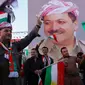 Warga Kurdi Irak berkumpul sambil melambai-lambaikan bendera Kurdi di samping poster Pemimpin Kurdi, Massoud Barzani saat melakukan aksi untuk meminta referendum kemerdekaan di Arbil, Irak utara (13/9). (AFP Photo/SAfim Hamed)