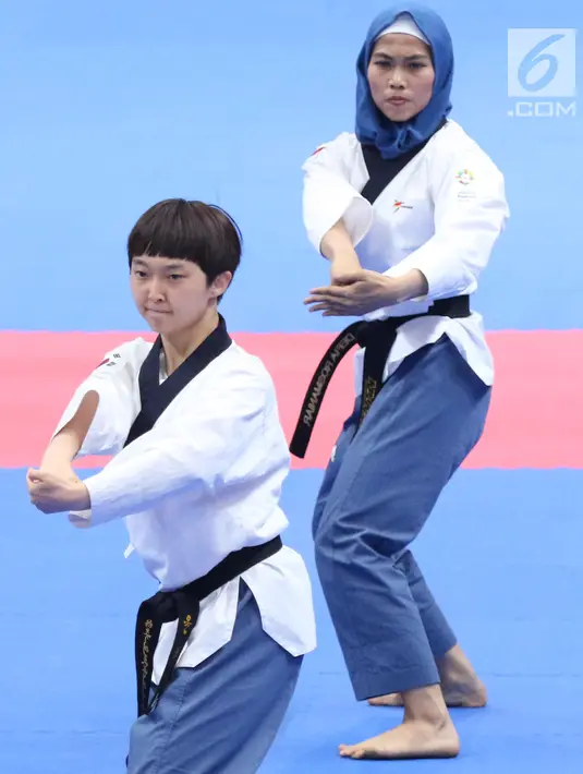 Atlet Taekwondo putri Indonesia, Defia Rosmaniar saat laga bersama Yun Jihye (Korea Selatan) pada Semifinal Women Individual Poomsae di JCC, Jakarta, Minggu (19/8). Defia Rosmaniar berhasil meraih emas. (Liputan6.com/Helmi Fithriansyah)