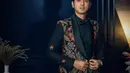 Menarik, Arya Saloka di red carpet Busan Film Festival mengenakan jas batik. Jas hitam bermotif batik floral bernuansa oranye dipadu dengan kemeja, celana panjang, dan dasi kupu-kupu hitam. [Foto: Instagram/netflixid]