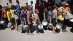 Anak-anak Palestina mengantre untuk menerima makanan panas dari dapur amal kamp pengungsi Nuseirat di Jalur Gaza yang dikepung Israel pada 11 September 2025. (Eyad BABA/AFP)