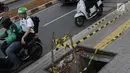 Pengendara melintas di dekat penutup trotoar yang rusak di kawasan Jalan RS Fatmawati, Jakarta, Selasa (14/7/2019). Dua buah penutup trotoar di Jalan RS Fatmawati rusak parah, kondisi ini mengganggu kenyamanan dan membahayakan pejalan kaki, terutama pada malam hari. (Liputan6.com/Helmi Fithriansyah)