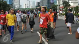 Seorang warga menjalani hukuman untuk memunguti sampah di kawasan Bundaran HI, Jakarta, Minggu (24/4).Selain denda uang, pria ini bisa menggantikannya dengan membersihkan sampah dengan sekantong plastik besar. (Liputan6.com/ Gempur M Surya)