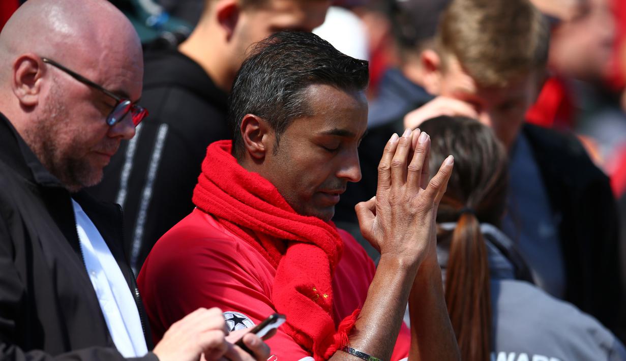 Seorang pendukung Liverpool berdoa sebelum pertandingan melawan Wolverhampton Wanderers pada lanjutan Liga Inggris di stadion Anfield (12/5/2019). Liverpool gagal meraih juara Liga Inggris untuk pertama kalinya sejak 1990 karena Manchester City menang atas Brighton 4-1.(AP Photo/Dave Thompson)