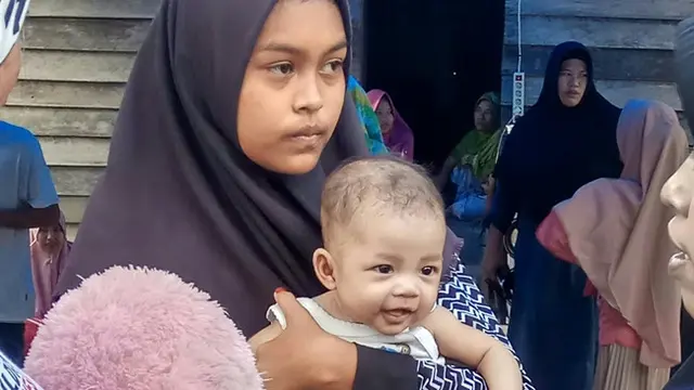 Remaja Andini bersama adik kecilnya ketika menyambut orang yang datang ke rumahnya