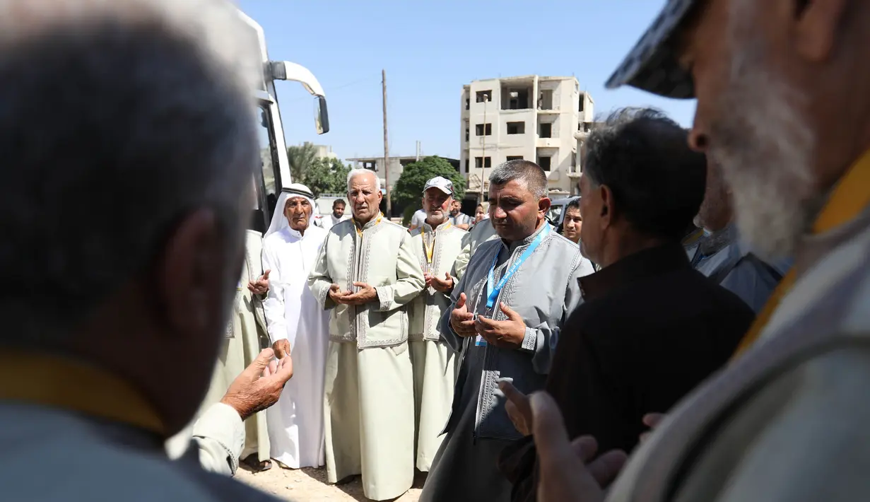 Warga Suriah dari provinsi Idlib, berdoa sebelum menaiki bus ke Tanah Suci Makkah di kota Binnish, Senin (22/7/2019). Jemaah calon haji asal Suriah melakukan perjalanan ke Arab Saudi untuk menjalankan ibadah haji dari perbatasan Bab al-Hawa yang berseberangan dengan Turki. (Omar HAJ KADOUR/AFP)