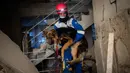 Anggota kelompok hak asasi hewan Turki, HAYTAP, Mehmet Gurkan menyelamatkan seekor anjing yang terperangkap selama tujuh hari di dalam rumah yang terkena dampak gempa di Antakya, Turki, 12 Februari 2023. (AP Photo/Bernat Armangue)