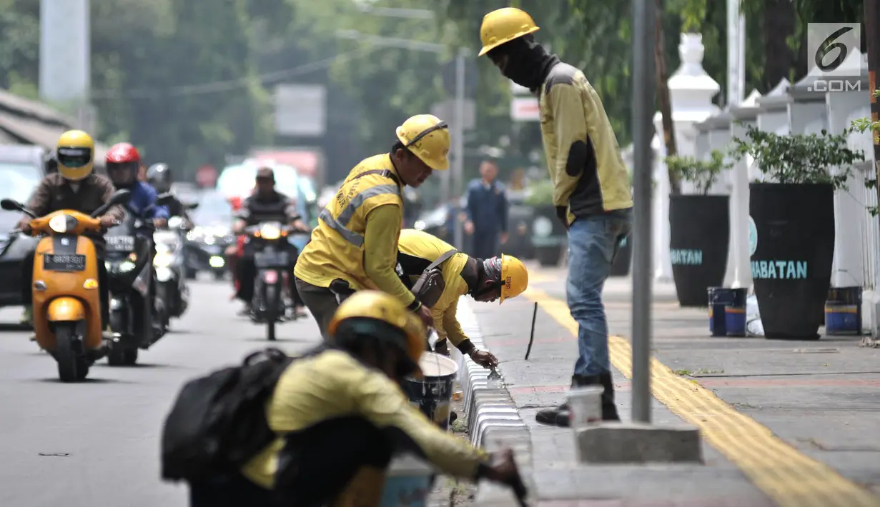 Petugas Suku Dinas Bina Marga Jakarta Timur saat menyelesaikan pengecatan trotoar di Jalan Persahabatan Raya, Jakarta, Rabu (27/3). Kegiatan pengecatan ini rutin dilakukan guna merawat sekaligus mempercantik jalur pedestrian tersebut. (merdeka.com/Iqbal S. Nugroho)