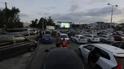 Suporter menyaksikan pertandingan Viktoria Plzen dan Sparta Praha di sebuah bioskop drive-in di Pilsen, Republik Ceko, Rabu (27/5/2020). Di tengah pandemi COVID-19, suporter Ceko dapat menyaksikan pertandingan bola lewat layar di bioskop drive-in. (AP Photo/Petr David Josek)