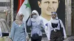 Warga berjalan di depan poster Presiden Bashar al-Assad dekat Masjid Agung Umayyah di Damaskus, Suriah, 23 September 2021. Berbeda dengan kondisi sebagian besar negeri, Ibu Kota Damaskus tidak terlalu menderita akibat perang Suriah yang sudah memasuki tahun ke-10. (LOUAI BESHARA/AFP)