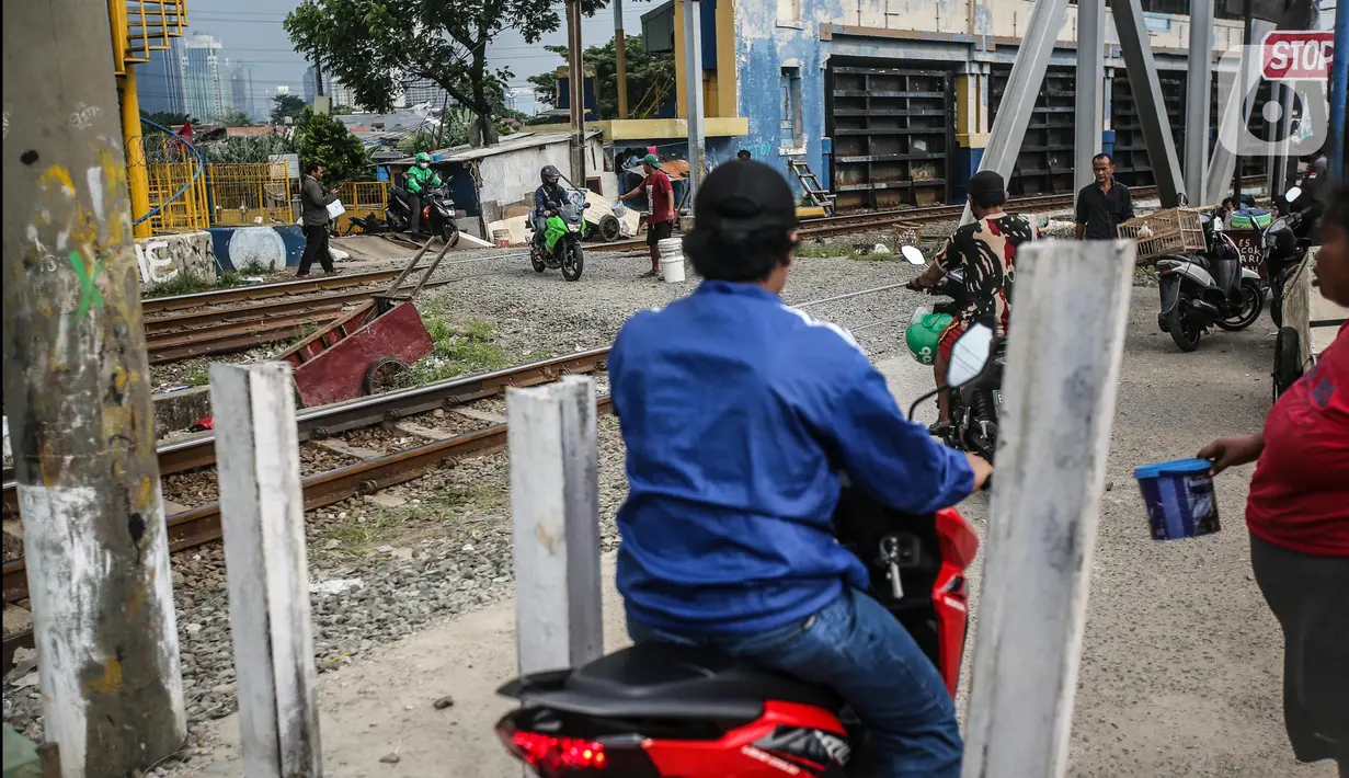 Kendaraan roda dua tetap melintas walaupun sudah ditutup di perlintasan kereta api di kawasan Tanah Abang-Palmerah Jakarta, Jumat (24/6/2022). PT Kereta Api Indonesia (Persero) atau KAI Daop 1 Jakarta menutup enam perlintasan liar sebagai upaya mewujudkan keselamatan dan keamanan perjalanan KA serta masyarakat.  (Liputan6.com/Faizal Fanani)