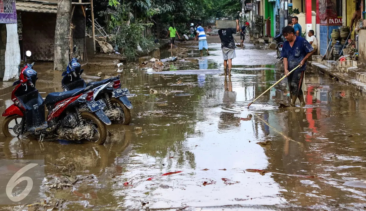 Warga membersihkan jalan yang dipenuhi lumpur usai banjir menggenangi komplek Pondok Gede Permai Jatiasih, Bekasi, Jumat (22/04). (Liputan6.com/Fery Pradolo)