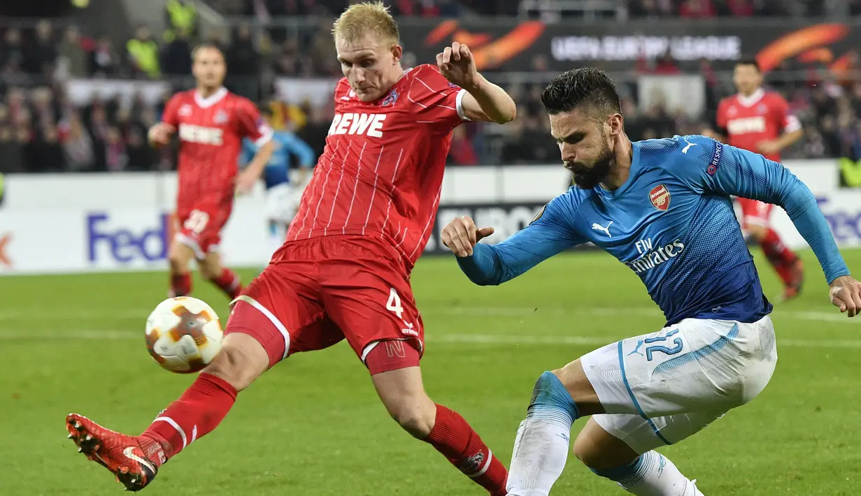 Pemain FC Cologne, Frederik Sorensen menghalangi tembakan pemain Arsenal, Olivier Giroud pada laga grup H Liga Europa di Rhein  Energie Stadium, Cologne, (23/11/2017). Arsenal kalah 0-1. (AP/Martin Meissner)