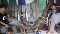 Pengerajin berbahan dasar kulit ular tengah memproduksi tas di bengkel kerja di Cibitung, Jawa Barat, Selasa (12/4). Dalam sebulan dapat memproduksi 200 buah dengan harga jual 50 ribu-8 juta. (Liputan6.com/Angga Yuniar)