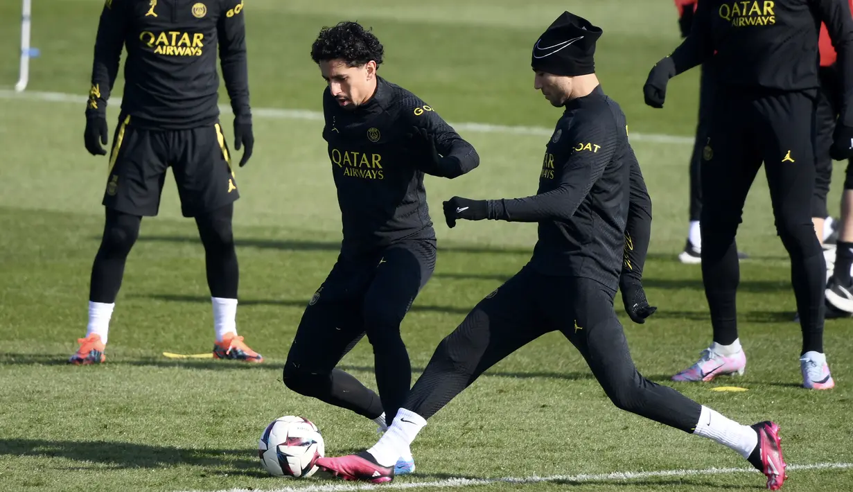 Bek PSG Achraf Hakimi (kedua kanan) memainkan bola dengan Marquinhos selama sesi latihan jelang menjamu Nantes pada Liga Prancis, di tempat latihan klub di Saint-Germain-en-Laye, sebelah barat Paris, Jumat (3/3/2023). PSG meraih 2 kemenangan beruntun setelah mengalami 3 kekalahan di 3 kompetisi berbeda. (Photo by FRANCK FIFE / AFP)