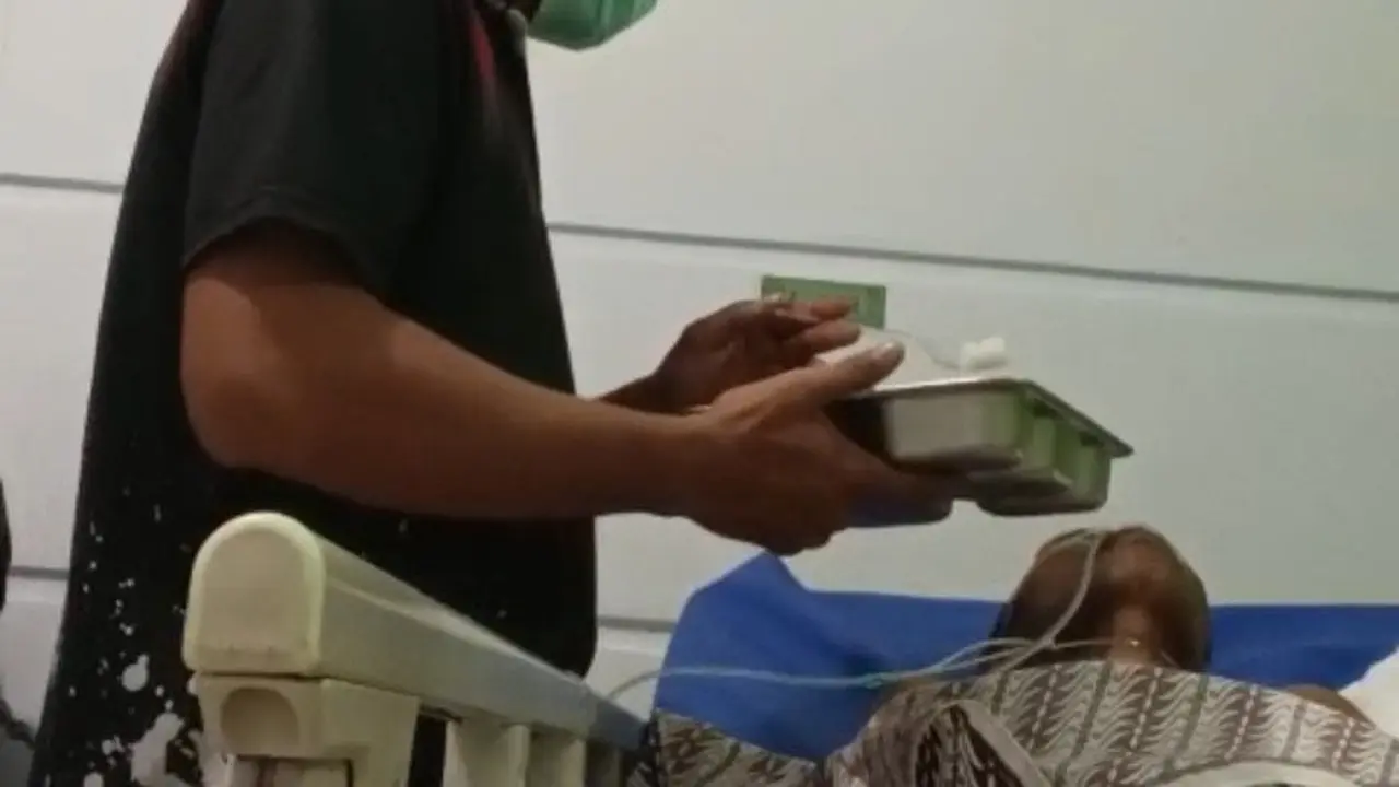 Petugas Lapas Kelas IIA Manado, Imanuel Novel Ransun saat menyuapi warga binaan yang dirawat di rumah sakit