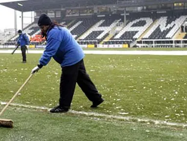 Ground staff try to clear ice from the pitch before Fulham's Premier League match against Blackburn at Craven Cottage, London, on January 10, 2009. AFP PHOTO / Glyn Kirk