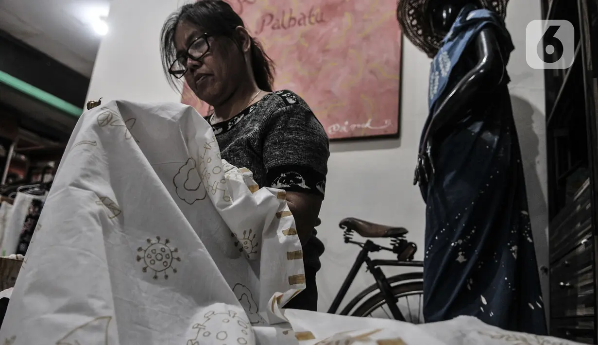 Perajin menyelesaikan pembuatan batik edisi Jakarta Terkini di Rumah Batik Palbatu, Kamis (15/10/2020). Kain batik Jakarta Terkini bergambar virus Covid-19 dipadukan ikon-ikon Ibu Kota seperti Monas, Tanjidor, dan ondel-ondel dibanderol Rp250 ribu - Rp350 ribu per buah. (merdeka.com/Iqbal Nugroho)
