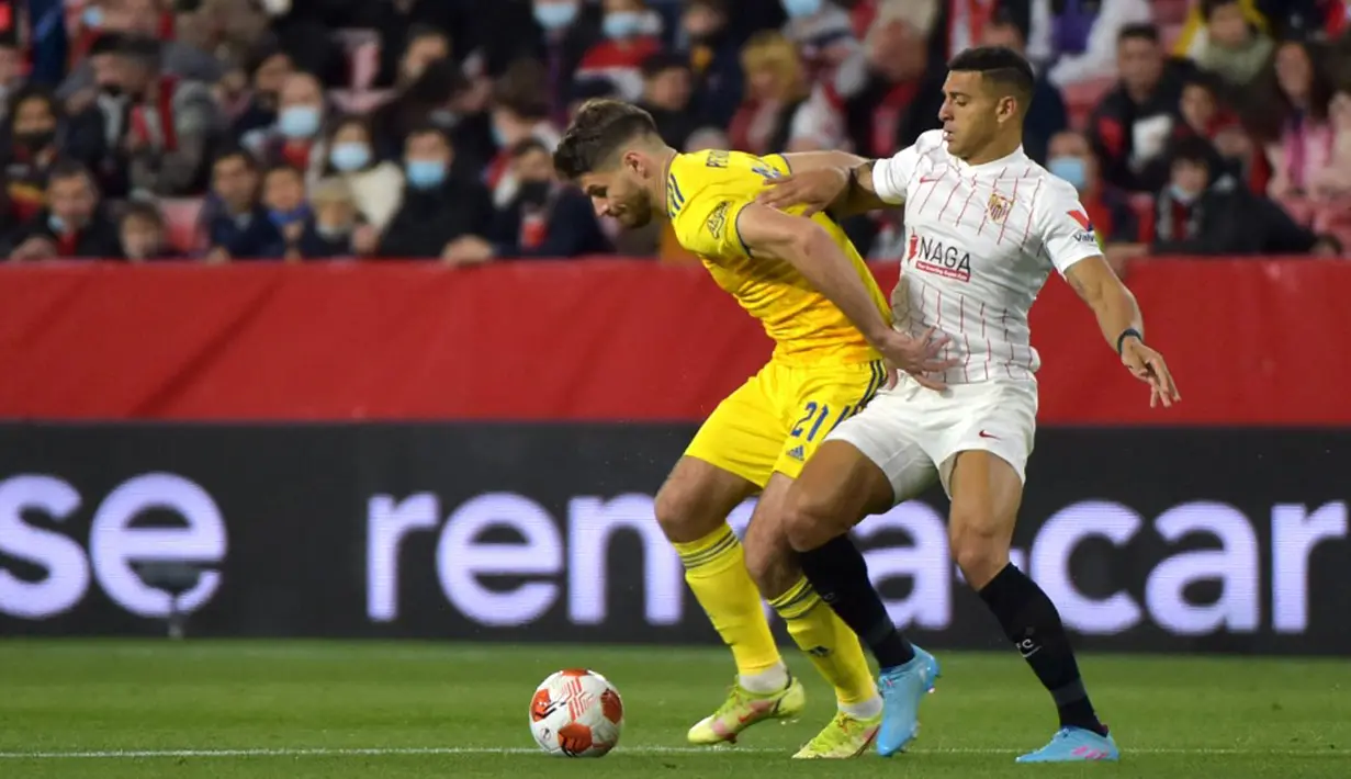 Pemain Sevilla Diego Carlos (kanan) bersaing memperebutkan bola dengan pemain Dinamo Zagreb Bruno Petkovic pada pertandingan sepak bola Liga Europa di Stadion Ramon Sanchez Pizjuan, Seville, Spanyol, 17 Februari 2022. Sevilla menang 3-1. (CRISTINA QUICLER/AFP)