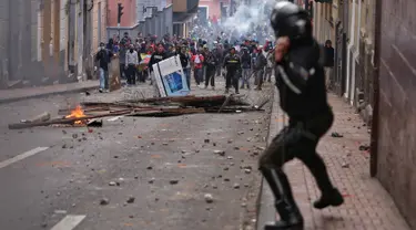 Polisi anti huru hara saat menghadapi demonstran selama bentrokan di Quito (7/10/2019). Para demonstran memprotes terhadap keputusan Presiden Ekuador Lenin Moreno yang mencabut subsidi bahan bakar. (AFP Photo/Cristina Vega)