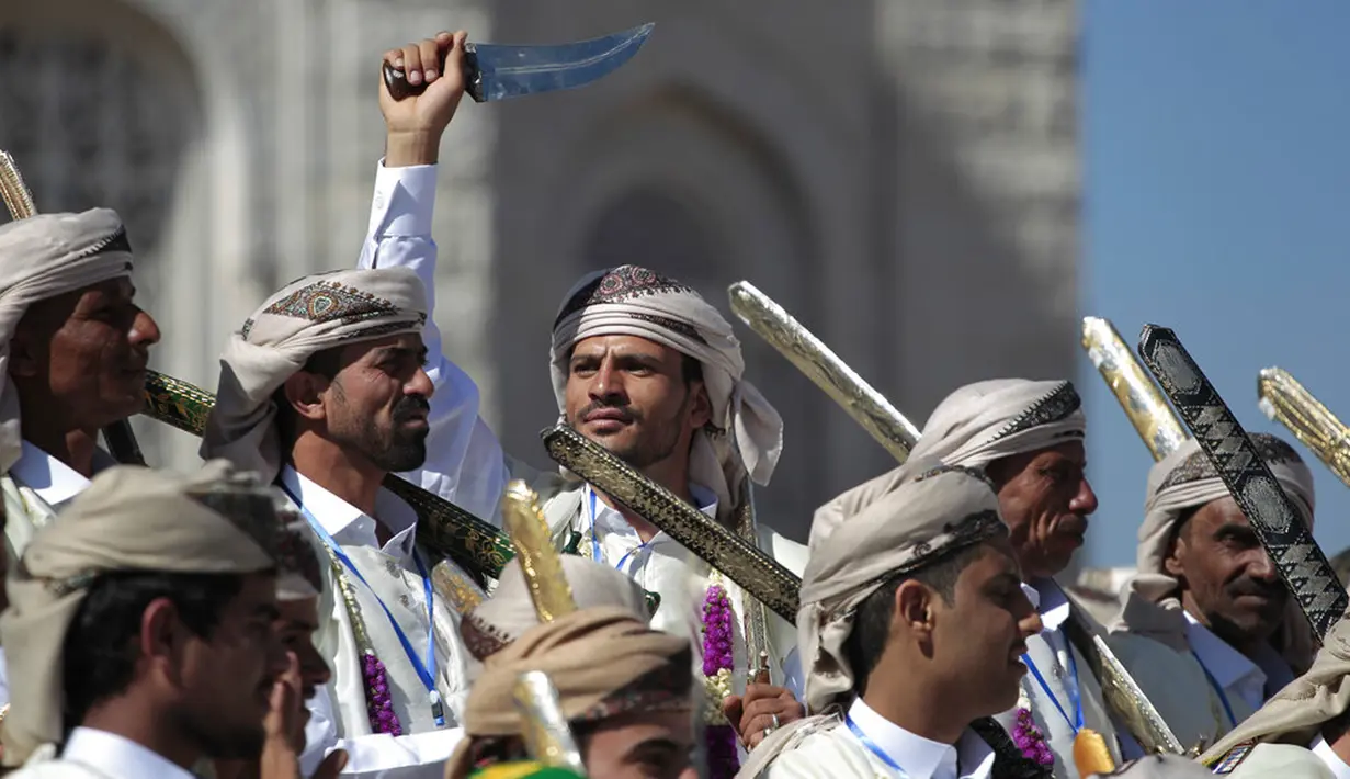 Seorang pengantin pria mengenakan pakaian tradisional sambil memegang belati saat menari pada acara nikah massal di Sanaa, Yaman, 2 Desember 2021. Houthi mengadakan nikah massal untuk ribuan pasangan. (AP Photo/Hani Mohammed)