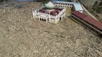 Pemandangan udara menunjukkan sisa-sisa pepohonan yang tumbang di pesantren dan masjid Darul Mukhlisin setelah banjir bandang di Aceh Tamiang, pada Rabu 10 Desember 2025. Banjir bandang dan tanah longsor yang menerjang Aceh, Sumatera Utara, dan Sumatera Barat yang terjadi beberapa pekan lalu mengakibatkan kerusakan parah pada sejumlah wilayah. (Aditya Aji/AFP)