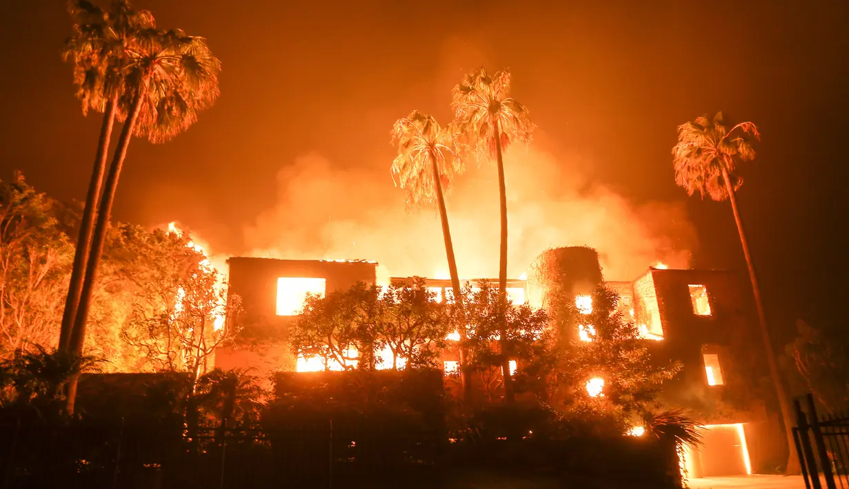 Kobaran api membakar sebuah rumah di Malibu, California, AS, Jumat (9/11). Departemen Pemadam Kebakaran setempat mendesak agar warga segera mengungsi ke tempat aman. (AP Photo/Ringo H.W. Chiu)