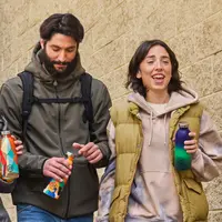 Pria dan wanita yang sedang bercanda-tawa sambil memegang botol dari 24Bottles (Foto dok : 24Bottles/fromAlphabet).