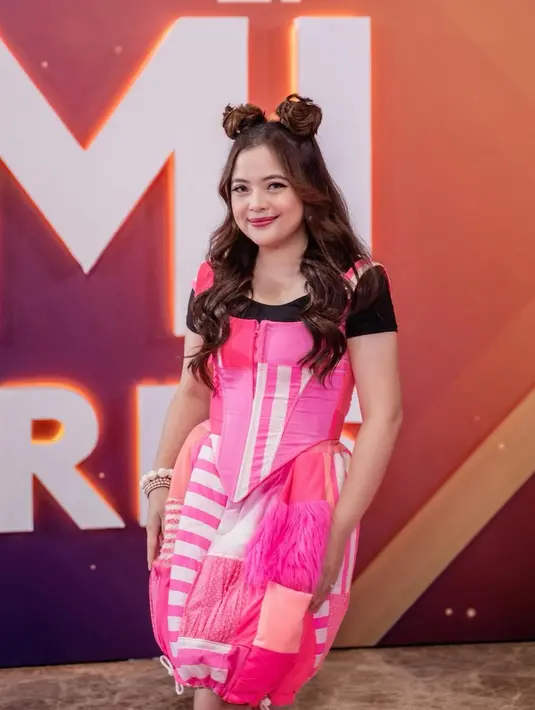 Tasya Kamila tampil cutesy dengan balon mini dress berwarna pink dari saat terima dua penghargaan dalam kategori lagu anak. Penampilannya makin manis dengan tatanan rambut spice bun. [@tasyakamila].