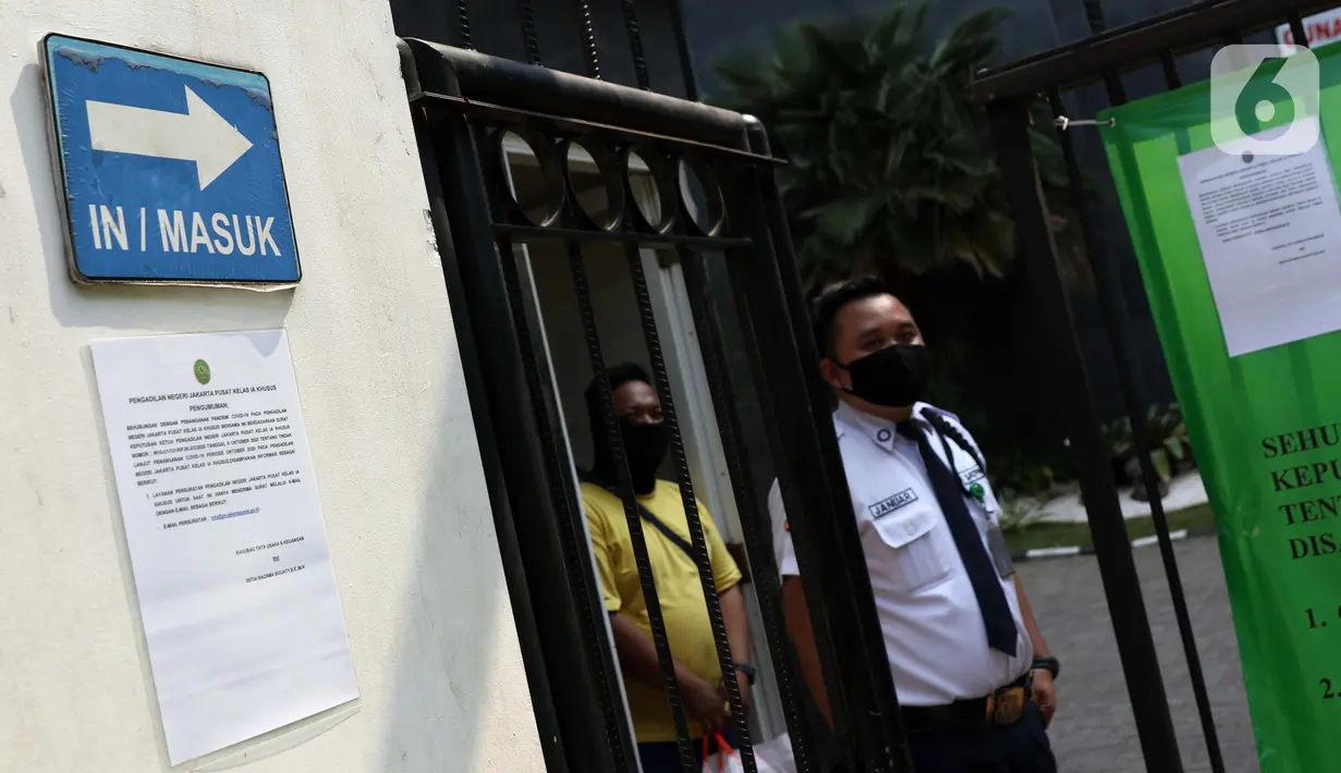 Petugas keamanan berjaga di sisi pagar gedung Pengadilan Negeri Jakarta Pusat, Rabu (7/10/2020). PN Jakarta Pusat menghentikan aktivitas selama tiga hari terhitung Rabu 7 Oktober hingga 9 Oktober 2020 karena adanya hasil tes pegawai yang reaktif COVID-19. (Liputan6.com/Helmi Fithriansyah)