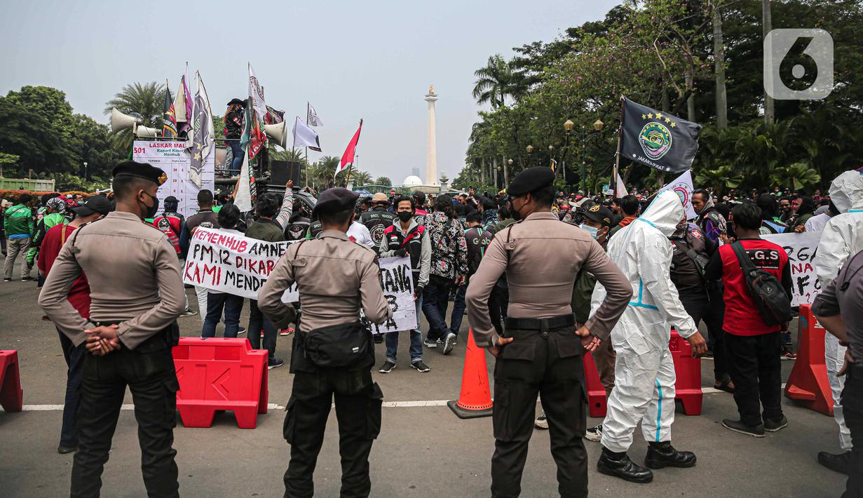 Polisi mengamankan aksi pengemudi ojek online di kawasan Patung Kuda, Jakarta, Rabu (5/1/2022). Para pengemudi ojek online menuntut Kementerian Perhubungan serta pengelola aplikasi untuk menepati janji kenaikan tarif ojek online. (Liputan6.com/Faizal Fanani)