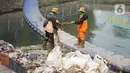 Petugas membersihkan sampah di sepanjang Kali Taman Anggrek, Jakarta, Rabu (8/7/2020). Banyaknya limbah menyebabkan Kali Taman Anggrek menjadi berwarna hitam dan berbau tidak sedap meskipun dibersihkan setiap hari. (Liputan6.com/Immanuel Antonius)