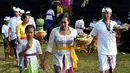 Umat Hindu membawa sesajen menuju pura untuk sembahyang Hari Raya Galungan di Jimbaran, Bali, Rabu (5/4). Galungan dirayakan oleh umat hindu di Bali sebagai hari kemenangan Dharma (Kebaikan) melawan Adharma (Keburukan). (SONNY TUMBELAKA/AFP)