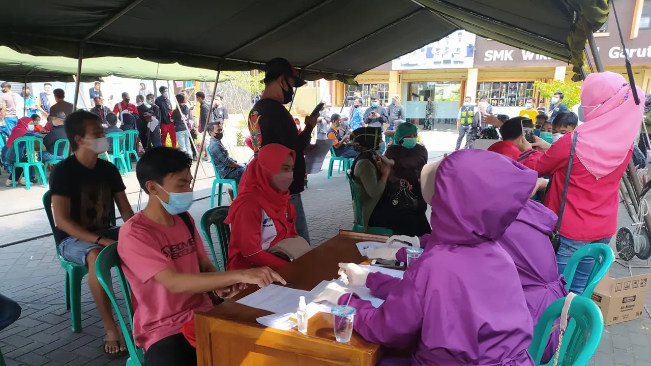 Nampak para petugas tenaga kesehatan (Nakes) tengah sibuk melakukan vaksinasi Covid-19 yang diselenggarakan Hiswana Migas Garut, bagi peserta yang berasal dari mitra Pertamina serta masyarakat sekitar.